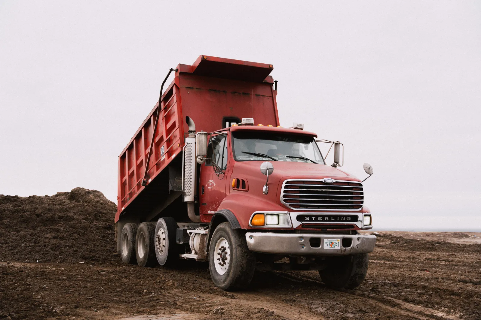 S&T Trucking dump truck tipping a load on a job site